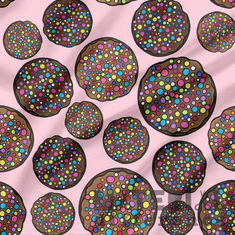 Pattern of colorful chocolate freckles on a pink background