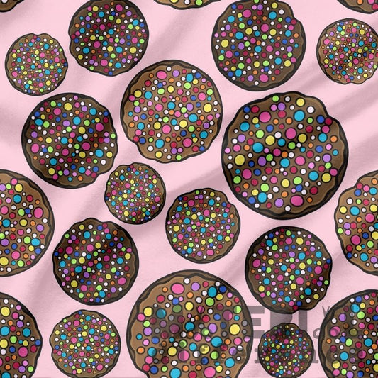 Pattern of colorful chocolate freckles on a pink background