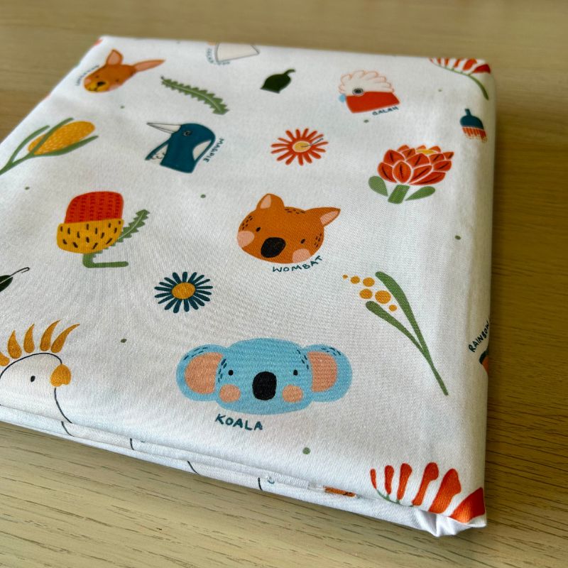 Cotton fabric featuring a colorful Australian-themed animal and flower print including a koala, kangaroo, echidna, wombat, and native flowers