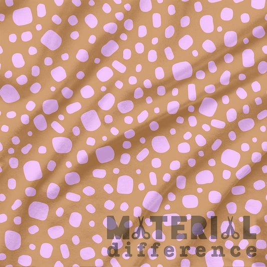 Fabric with pink polka dots on a brown background, featuring the text 'Material Difference'.