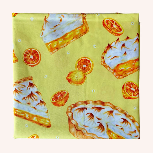 Piece of folded yellow fabric with lemon meringue pie pattern