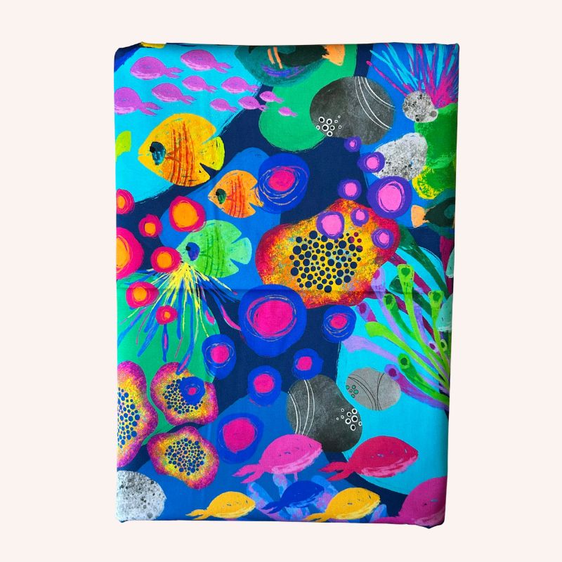 Fabric featuring a vibrant, multicolored abstract underwater or floral pattern with fish and coral-like motifs 