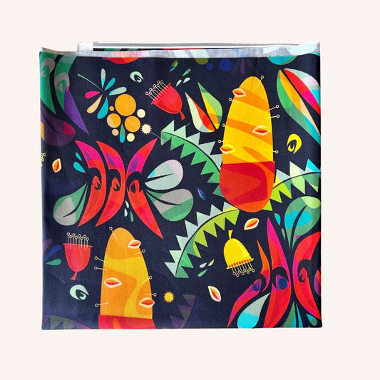 A square fabric item, likely a napkin or small scarf, featuring a vibrant, colorful abstract pattern on a dark navy blue background.