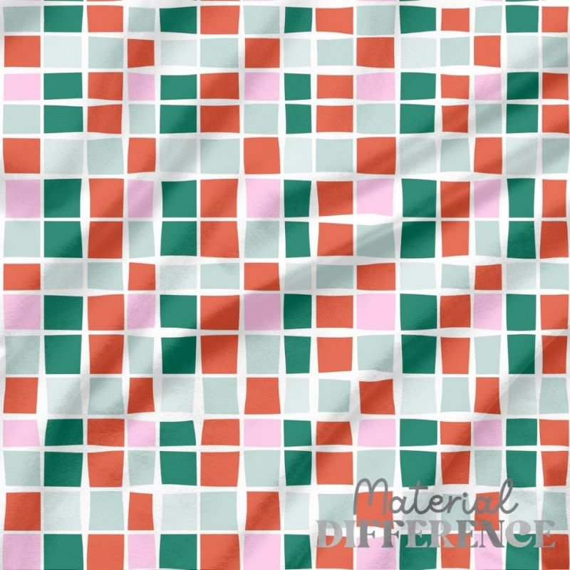 Colorful checkered fabric with a pattern of squares in red, green, and pink on a white background.