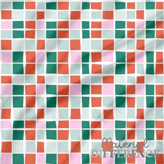 Colorful checkered fabric with a pattern of squares in red, green, and pink on a white background.