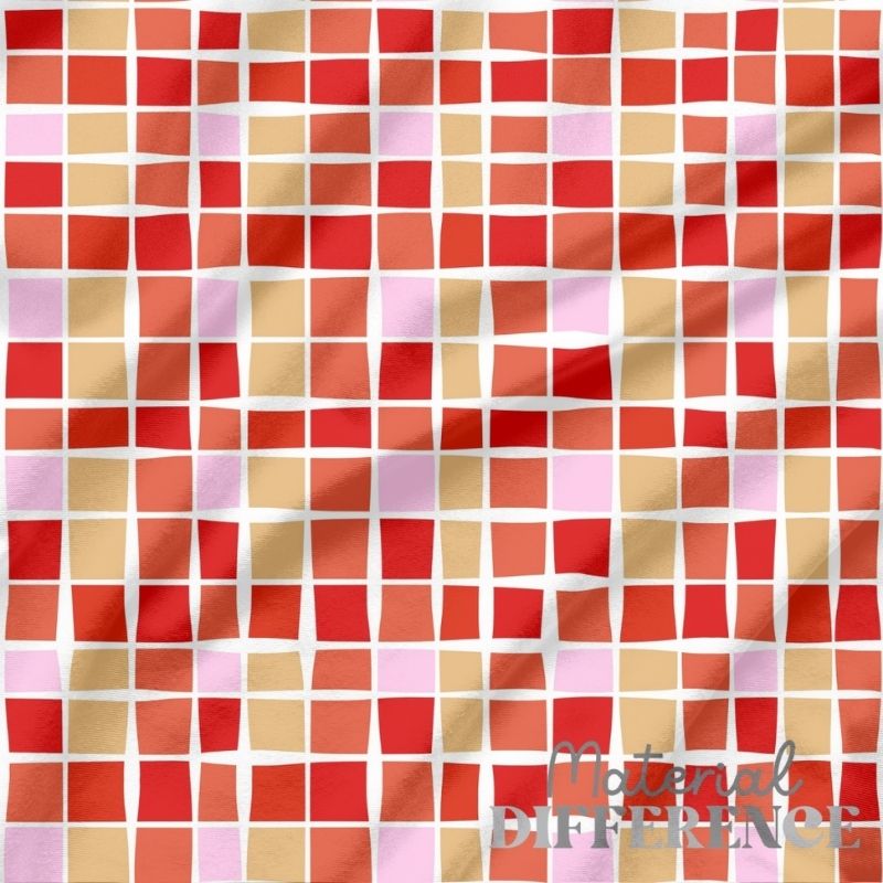 Patterned fabric with red, orange, and pink squares on a white background, featuring 'The Material Difference' brand.